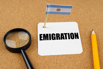 On the table is the flag of Argentina, a pencil and a sheet of paper with the inscription - Emigration