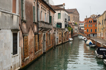 Fototapeta na wymiar Cozy narrow canals of Venice city with old traditional architecture, bridges and boats, Veneto, Italy. Tourism concept. Architecture and landmark of Venice. Cozy cityscape of Venice.