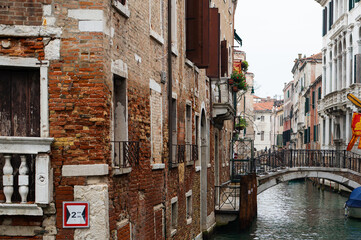 Fototapeta na wymiar Cozy narrow canals of Venice city with old traditional architecture, bridges and boats, Veneto, Italy. Tourism concept. Architecture and landmark of Venice. Cozy cityscape of Venice.
