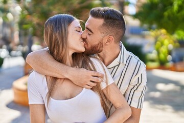 Obraz premium Man and woman couple hugging each other kissing at park