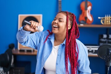 Obraz na płótnie Canvas African american woman artist singing song at music studio