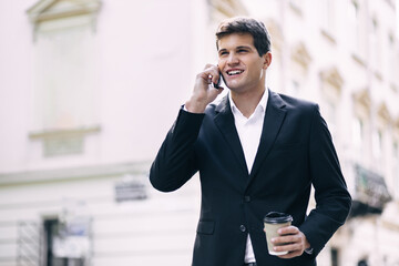 happy man in a suit and shirt smiling talking on the phone on th
