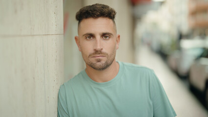 Obraz premium Young hispanic man standing with serious expression at street