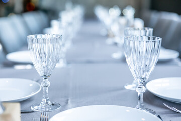 Beautifully laid tables with glasses and appliances at morning in restaurant