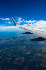 Obraz premium Boeing 737 wing. Flight over Amsterdam. blue sky with white clouds