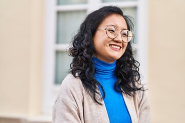 Young chinese woman smiling confident standing at street