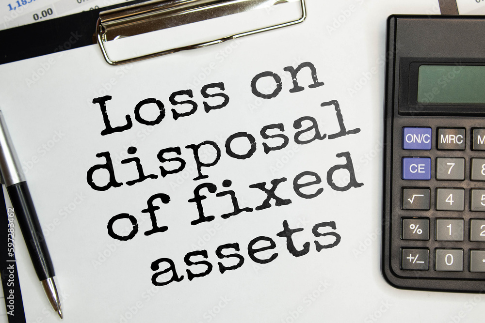Poster loss on disposal of fixed assets label on notepad with laptop and smartphone on wooden table.