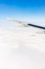 View from the airplane window at a beautiful cloudy sky and the airplane wing