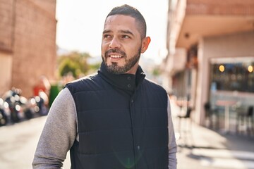 Young latin man smiling confident looking to the side at street