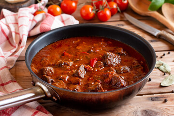 Classic Czech goulash in a frying pan, delicious heavy food on table