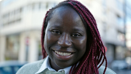 African woman with braided hair smiling confident at street