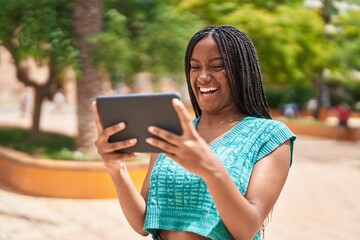 African american woman smiling confident watching video on touchpad at park