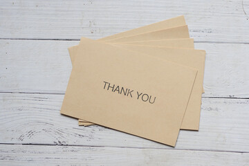 thank you message and envelope on wooden table