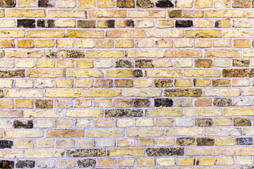 Pattern of yellow and black in a brick wall.