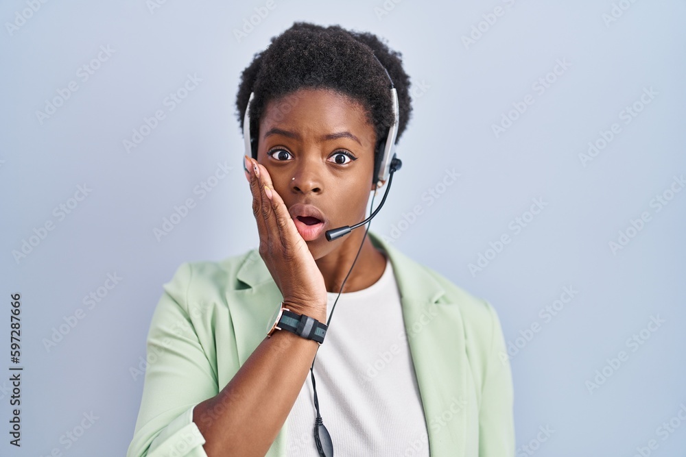 Poster African american woman wearing call center agent headset afraid and shocked, surprise and amazed expression with hands on face