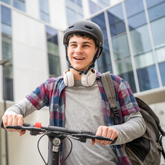 Young man caucasian teenager with electric kick push scooter in city