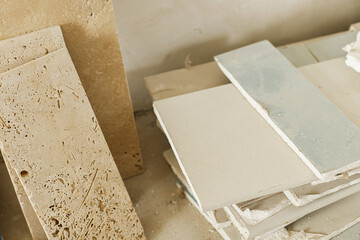 Travertine tiles and plasterboard against gypsum plaster wall. Construction of house and home...