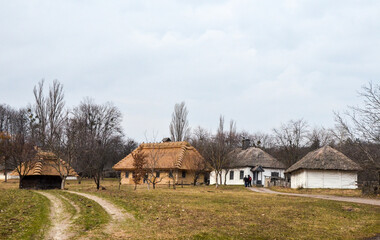 Rural landscape with authentic wooden houses with thatched roof at of traditional Ukrainian village