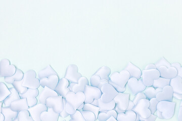 Textile hearts confetti on a blue pastel background. Monochrome concept with copy space.