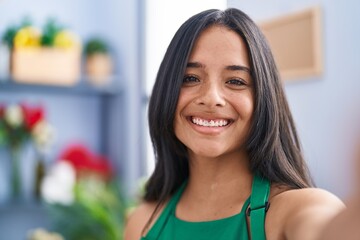 Young hispanic woman florist make selfie by camera at florist shop