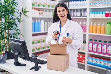 Young beautiful hispanic woman pharmacist scanning pills bottle at pharmacy