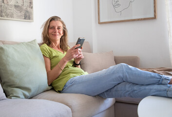 woman with phone relaxing in living room