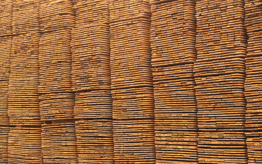 Wooden boards are stored outdoors. Wooden boards, lumber, industrial wood, timber. Pine wood timber stack of natural rough wooden boards on building site.