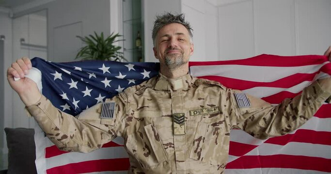 Portrait of a soldier who raises the American flag. Smile on your face, patriotism