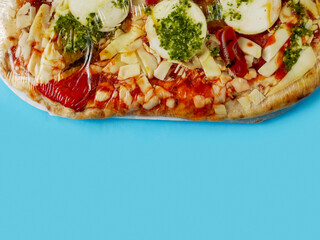 Italian style uncooked pizza on blue color background. Premium product with high quality ingredients.