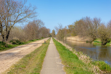 Gravel nature path along the canal and trees on the side, The Pieterpad is a long distance walking route in Netherlands, The trail runs from northern part of Groningen to end just south of Maastricht.