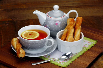 Tazza da tè con pasticcini di pasta sfoglia e teiera