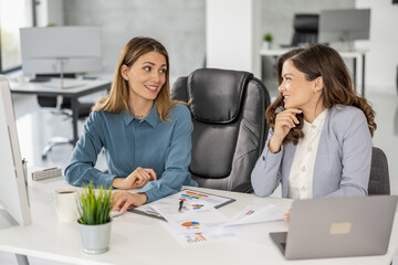 Business women working together on computer in modern office