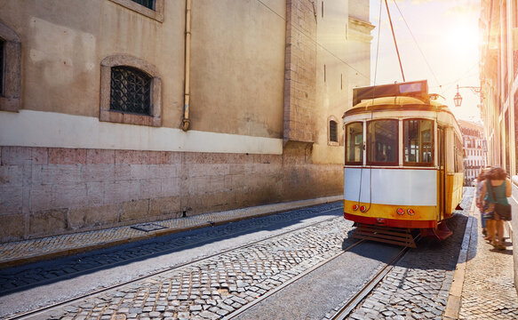 Lisbon, Portugal. Vintage retro tram on narrow bystreet tramline in Alfama district of old town. Popular touristic attraction Lisboa city. Public tramways trasport lisbon city