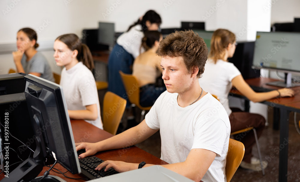 Poster positive male student using pc and studying computer science in the classroom
