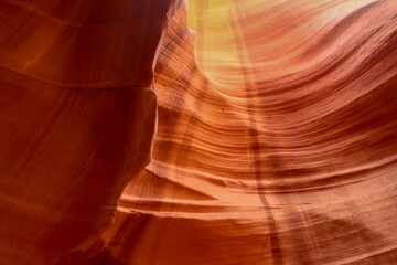 Etched erosion in the sandstone slots of Antelope Canyon with shadows and golden light streaming down the walls at the Navajo Park and Recreation area in Arizona