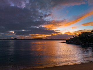 Aerial sunrise seascape with calm seas and a mix of high and low cloud