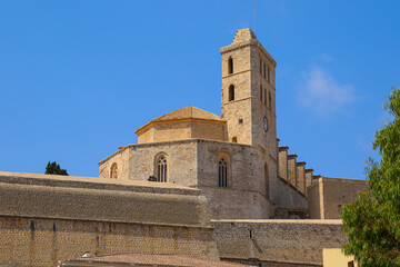 Fototapeta premium Bell tower of the Saint Mary Cathedral above the ramparts of the Castle of Eivissa in Dalt Vila, the old city center of Ibiza in the Balearic Islands, Spain