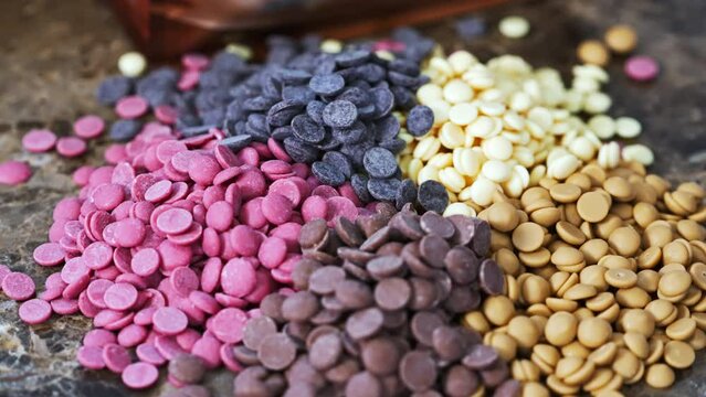 Ruby white and dark chocolate callets closeup on the kitchen counter - Tempered chocolate confectionery. High quality 4k footage