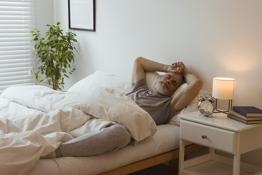 Senior man sleeping in bed at home