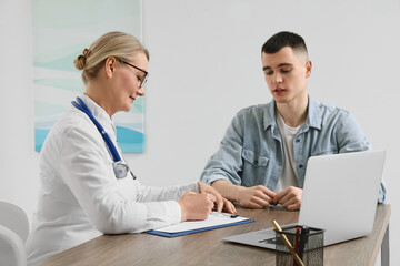 Fototapeta premium Professional doctor writing prescription at wooden table in clinic