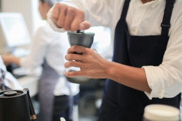 Barista coffee dripper and pour over filter with ground coffee in the funnel. Working in restaurant and cup with brewing process. Coffee shop concept.