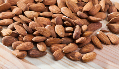 View of roasted almonds freely laid on wooden table