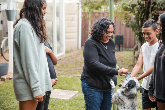 Aboriginal family playing with dog outside