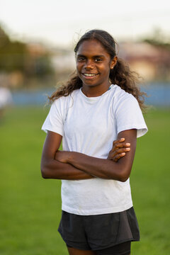 one aboriginal girl standing with arms crossed and looking at the camera