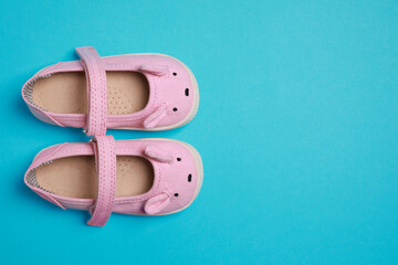 Cute baby shoes on light blue background, flat lay. Space for text