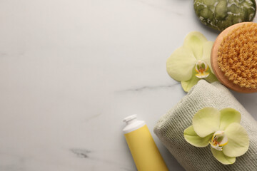 Fototapeta na wymiar Flat lay composition with spa products and beautiful flowers on white marble table. Space for text