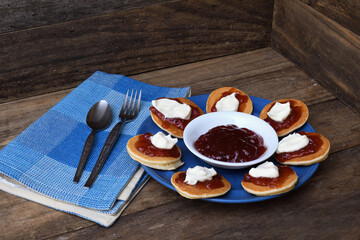 Pikelets Pancakes Battercakes strawberry jam whipped cream blue plate napkin spoon fork rustic...