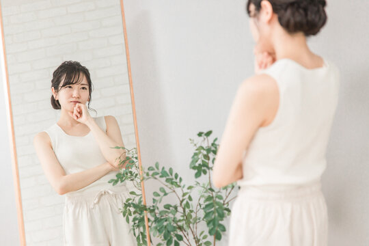 ダイエット・コンプレックス・体型に悩む鏡を見るアジア人女性

