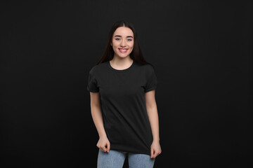 Woman wearing black t-shirt on dark background