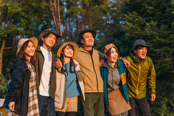 仲間と秋冬キャンプに来たキャンパーのアジア人の男女（グルキャン）
